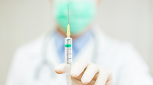 Close up of a doctor's hand holding a vaccine 